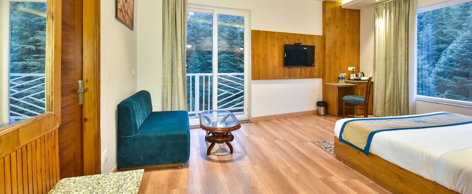 A view through the entrance of a sofa near the window in Premium Room With Balcony at DLS Ark Holiday Inn, Banikhet.
