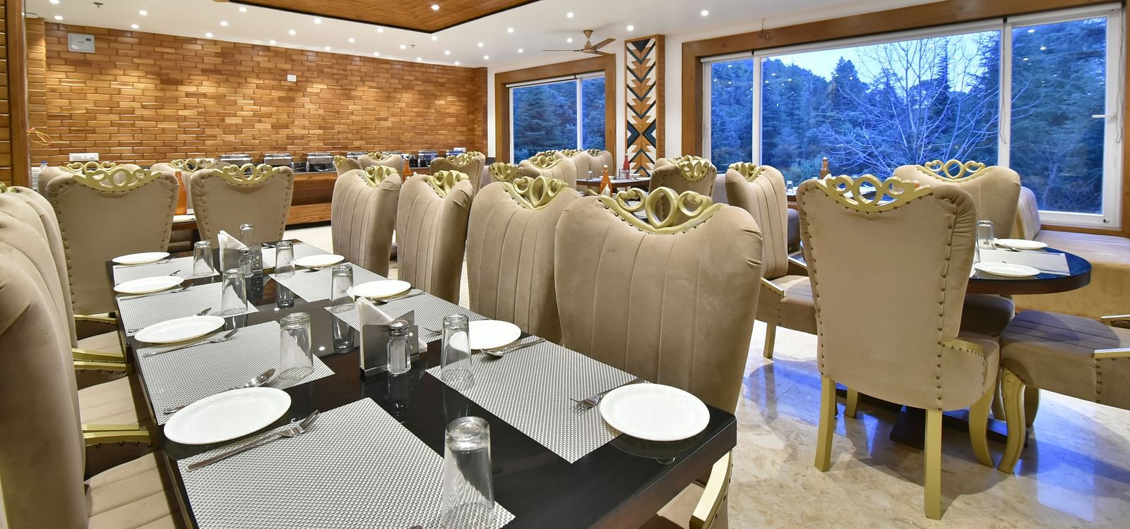 Dining area with comfortable chairs around tables at Rainbow Restaurant at DLS Ark Holiday Inn, Banikhet.