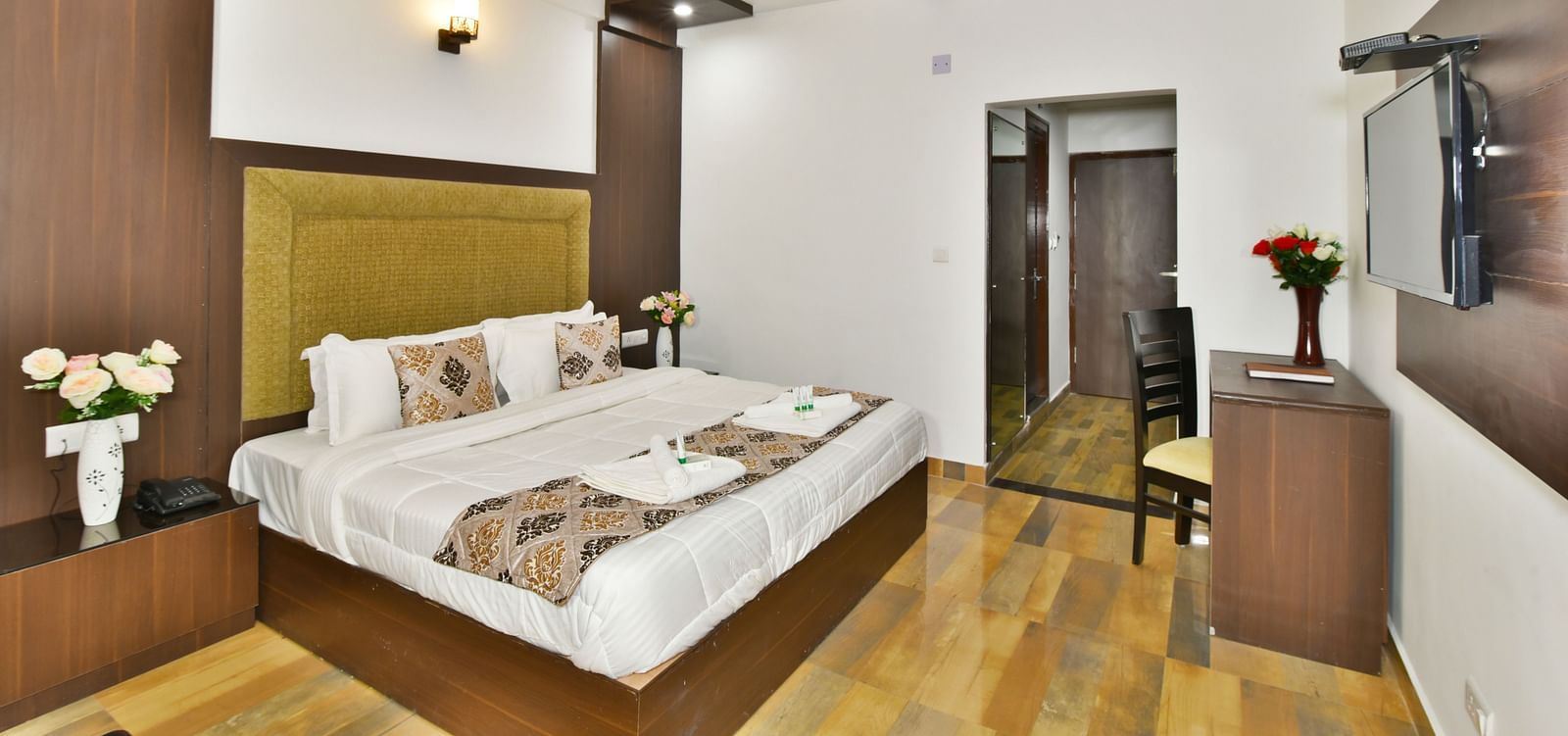 The spacious and well lit guest room that features a comfortable bed, a work desk, and a modern aesthetic | DLS Kapoor Resort Manali