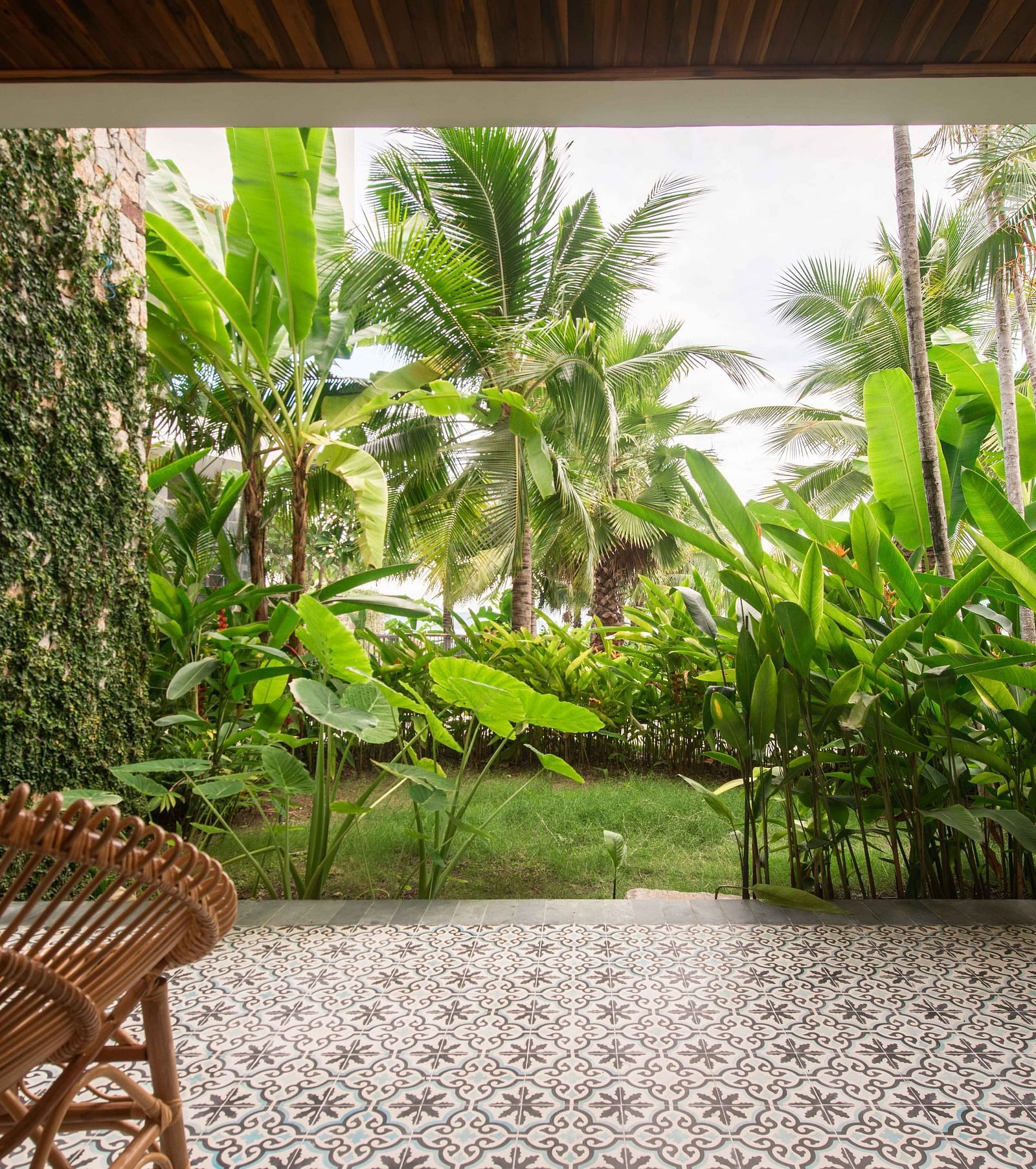 A balcony with a wooden chair to sit and relax and enjoy the garden view - Alibu Reosrt Nha Trang