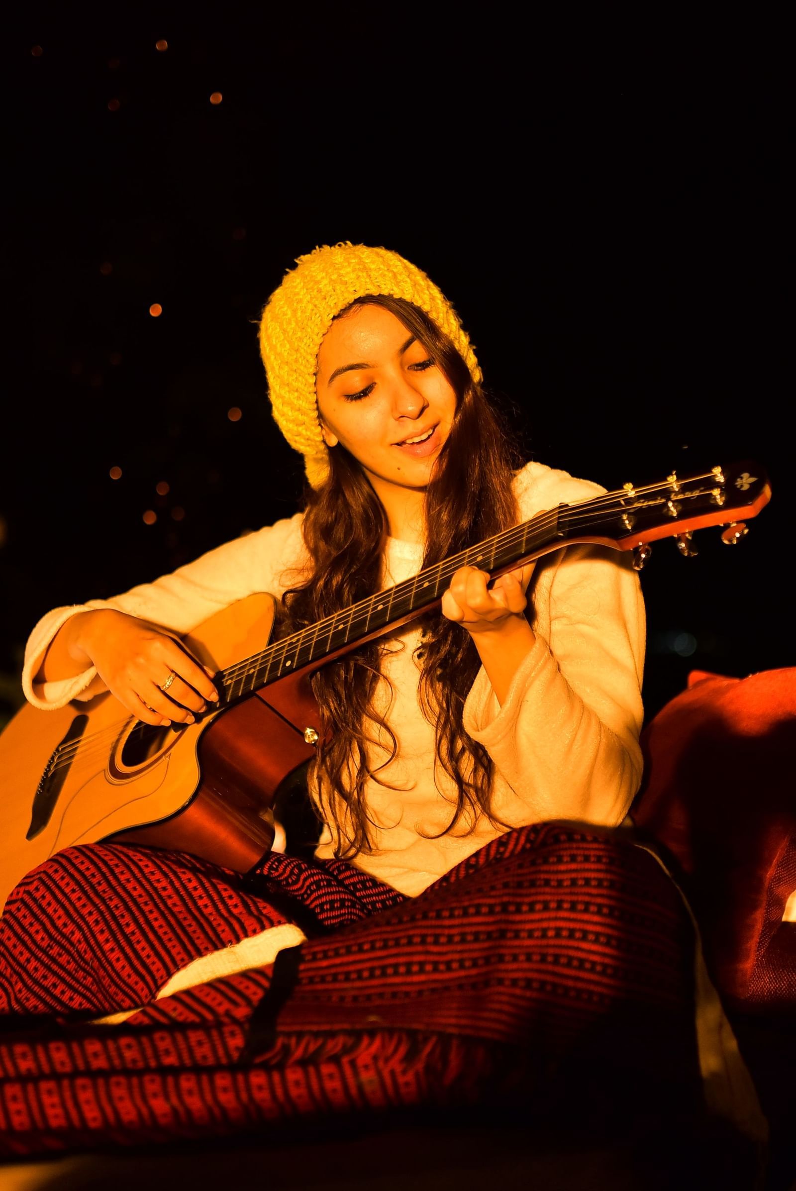 Musician playing guitar with starry sky as a backdrop at Polo Resort Cherrapunjee.