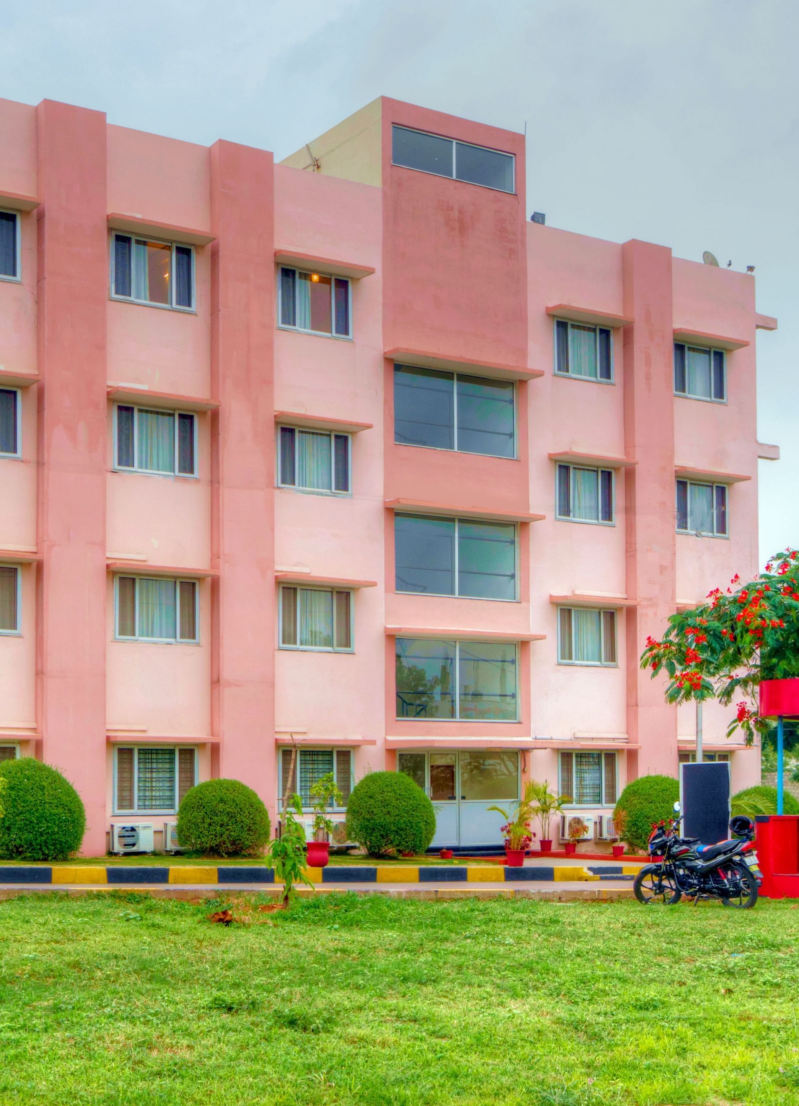 Exterior of Greens Inn with a lawn in front of it - Beautiful Hotel Grounds in Hyderabad.