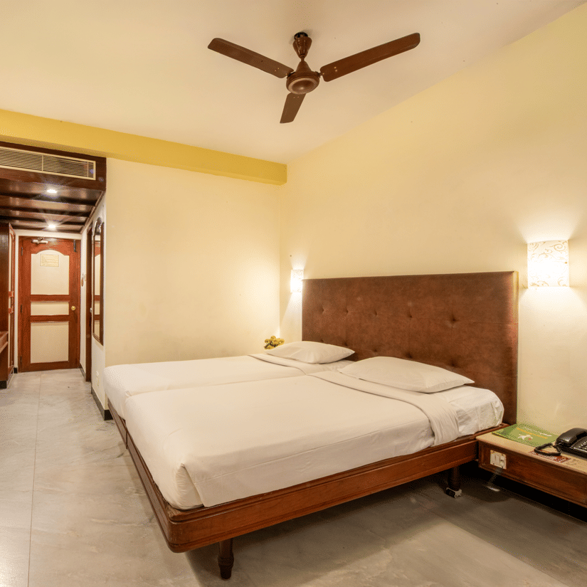 Standard Room at Jayaram Hotel, Pondicherry featuring a comfortable bed, television, work desk and contemporary interiors.