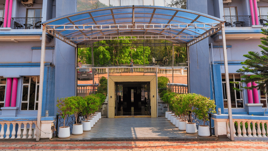 Facade of Mayur Retreat and Spa featuring multi-storied building surrounded by trees under a clear sky.