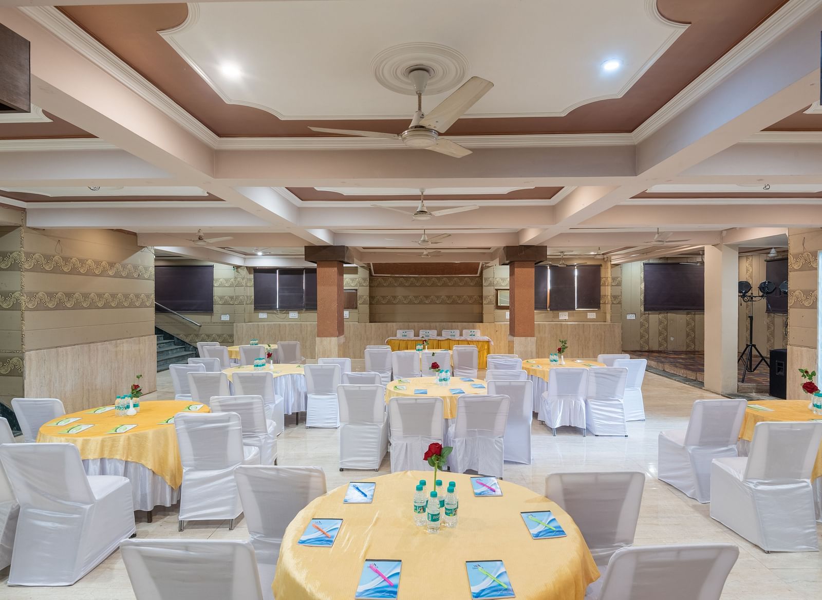 Banquet hall with round tables and chairs at DLS Park Grace, Haridwar.