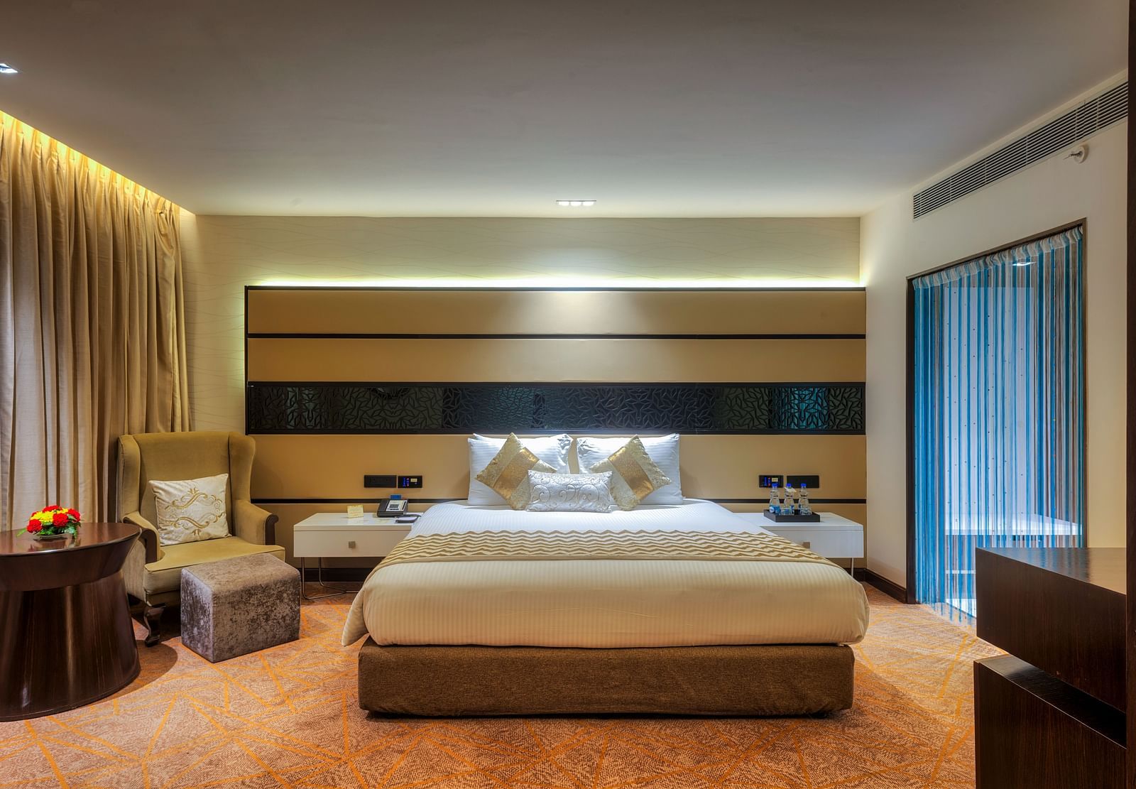 Theme Suite with a king size bed and a sofa chair at Grand Chennai By GRT Hotels.