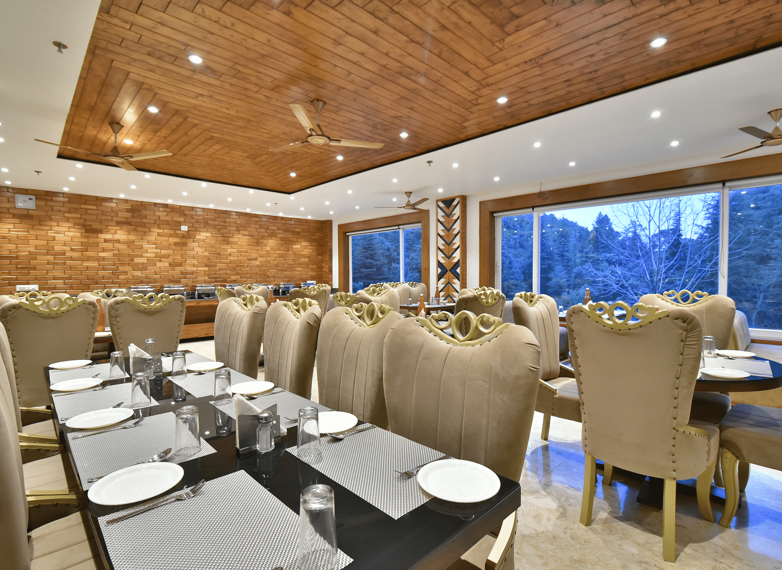 Dining area with comfortable chairs around tables at Rainbow Restaurant at DLS Ark Holiday Inn, Banikhet.