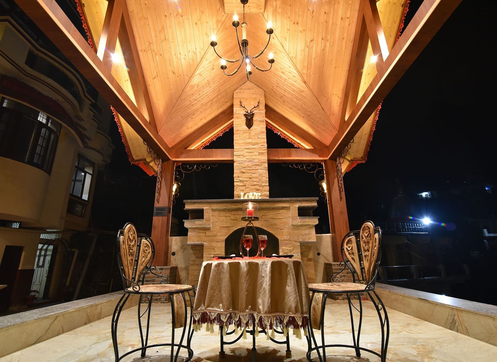 A Gazebo at DLS Dalhousie Valley Resort with beautiful chairs, table and a chandelier 
