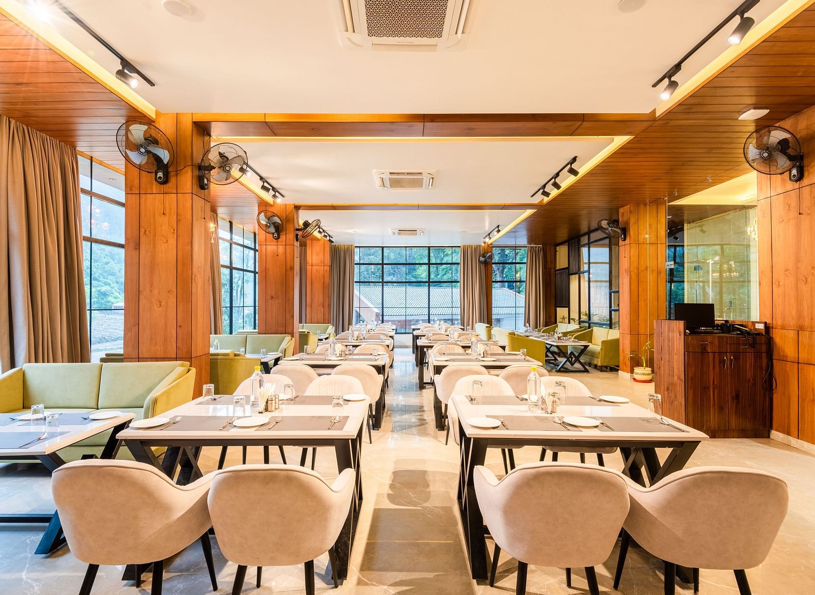 Restaurant at DLS Divine River Resort and Spa  with seating arrangement, large window and ambient lighting. 