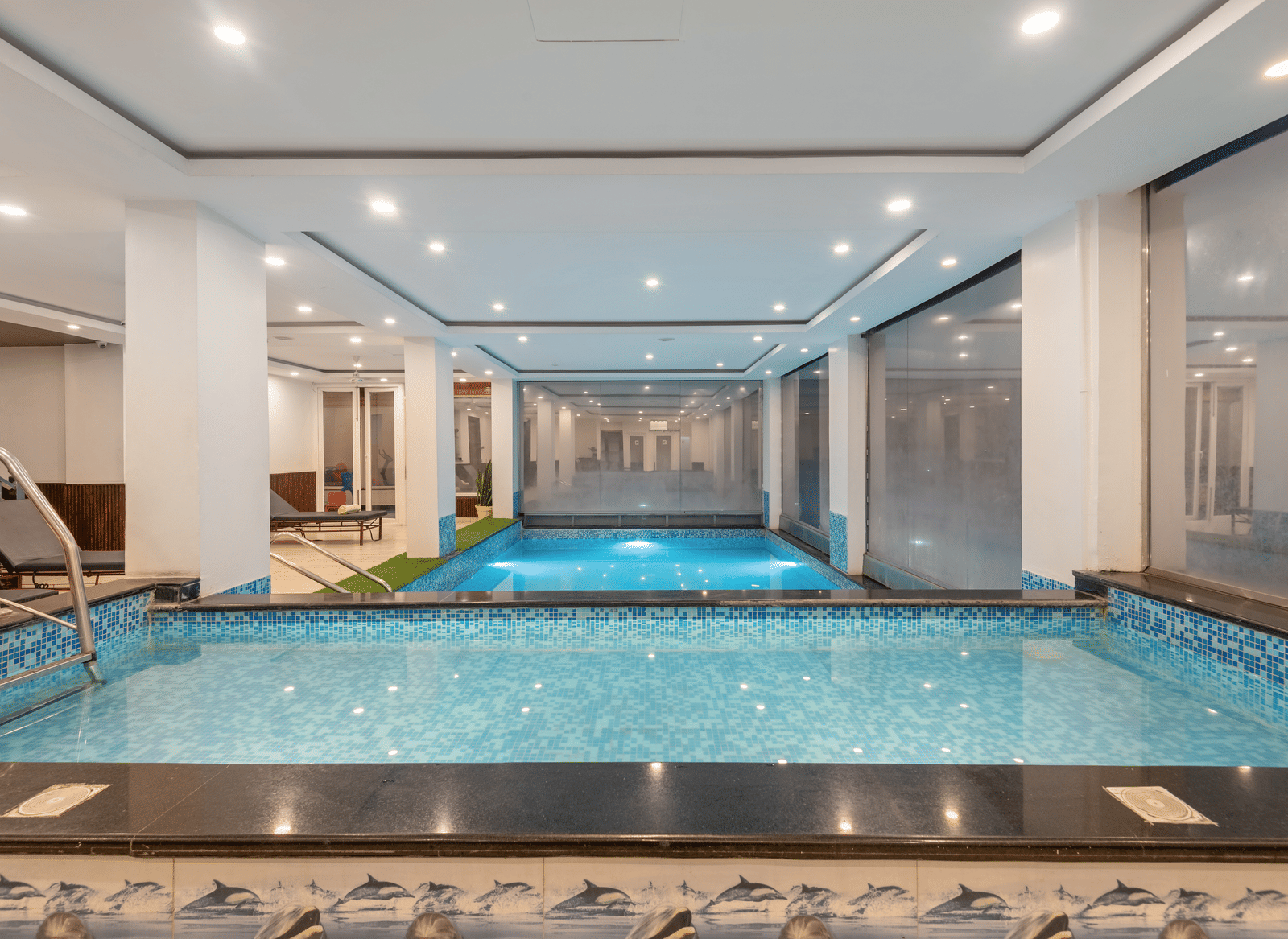 A wide view of the indoor pool facility at DLS Hotels on the Ganges Rishikesh with a clean tiled layout and abundant lighting offering guests a comfortable environment for swimming and quiet relaxation.