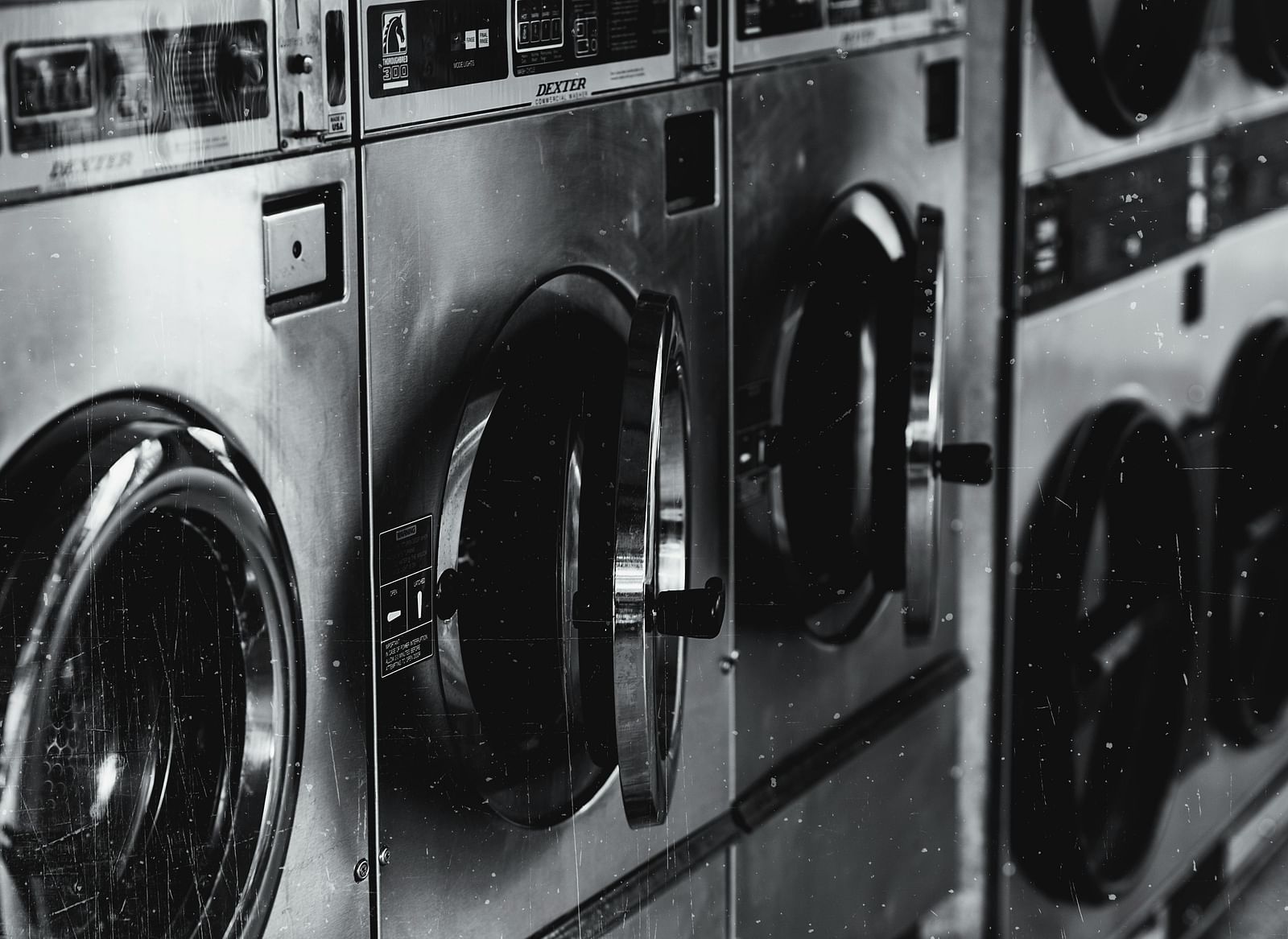 A gray scale image of washing machines in a laundry room.