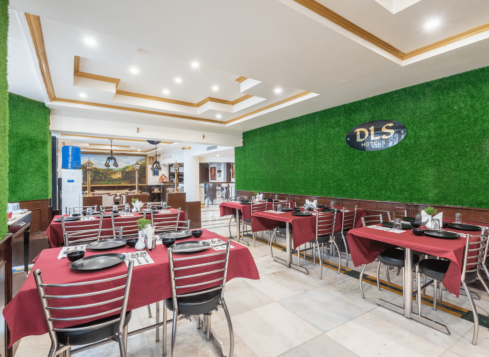 Image of dining area with red tablecloths, metal chairs, and a green wall | DLS The Pearl