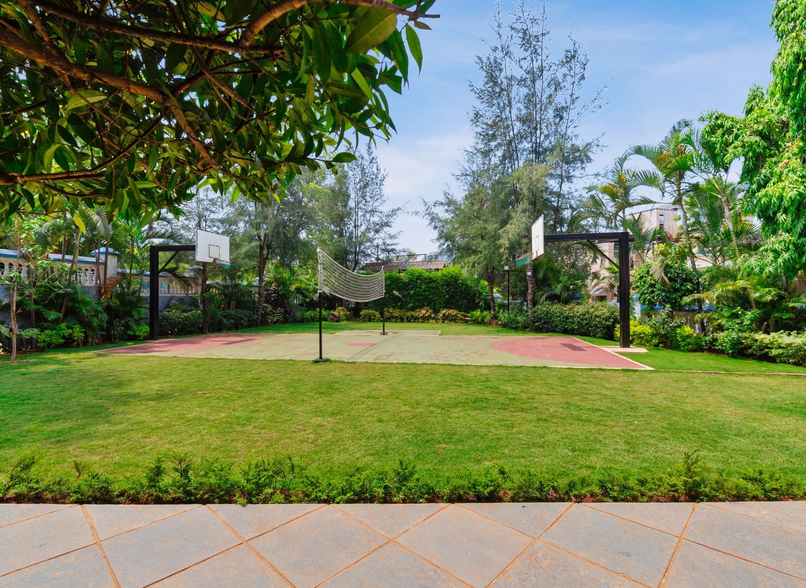 Front view of volleyball and basketball area surrounded by trees at Mayur Retreat.