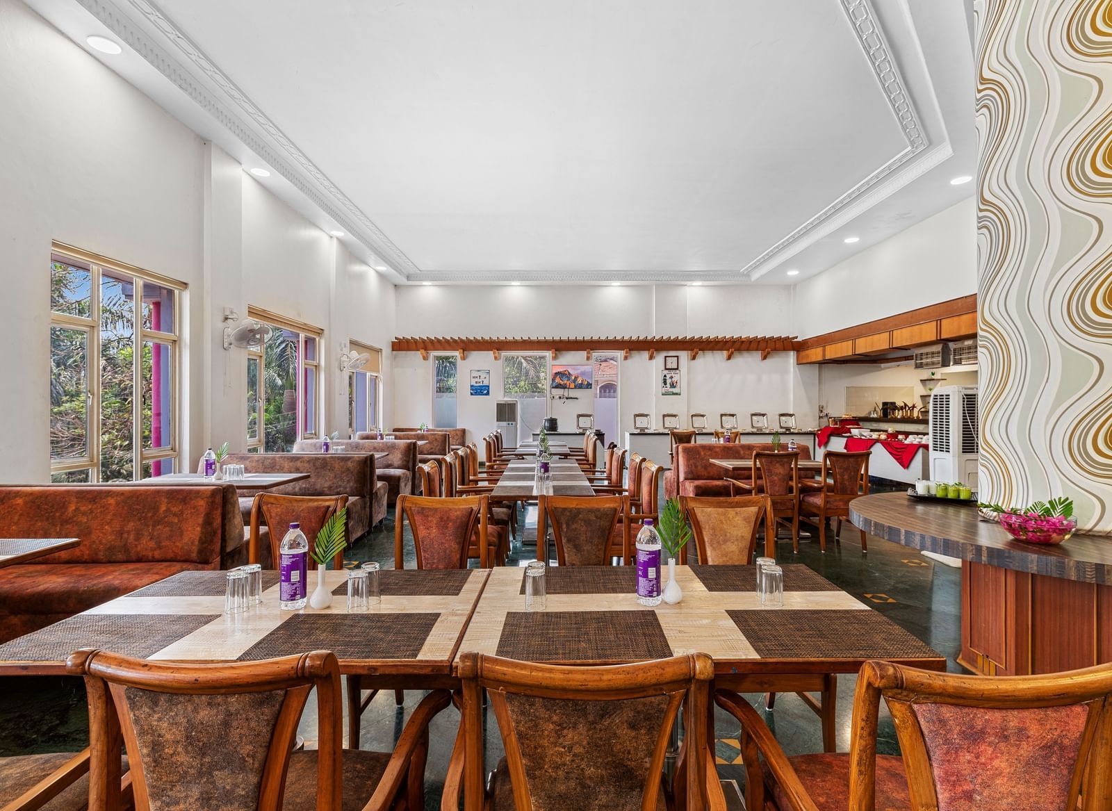Indoor dining area with wooden furniture and colourful decor, part of The Darbar Restaurant at Mayur Retreat.