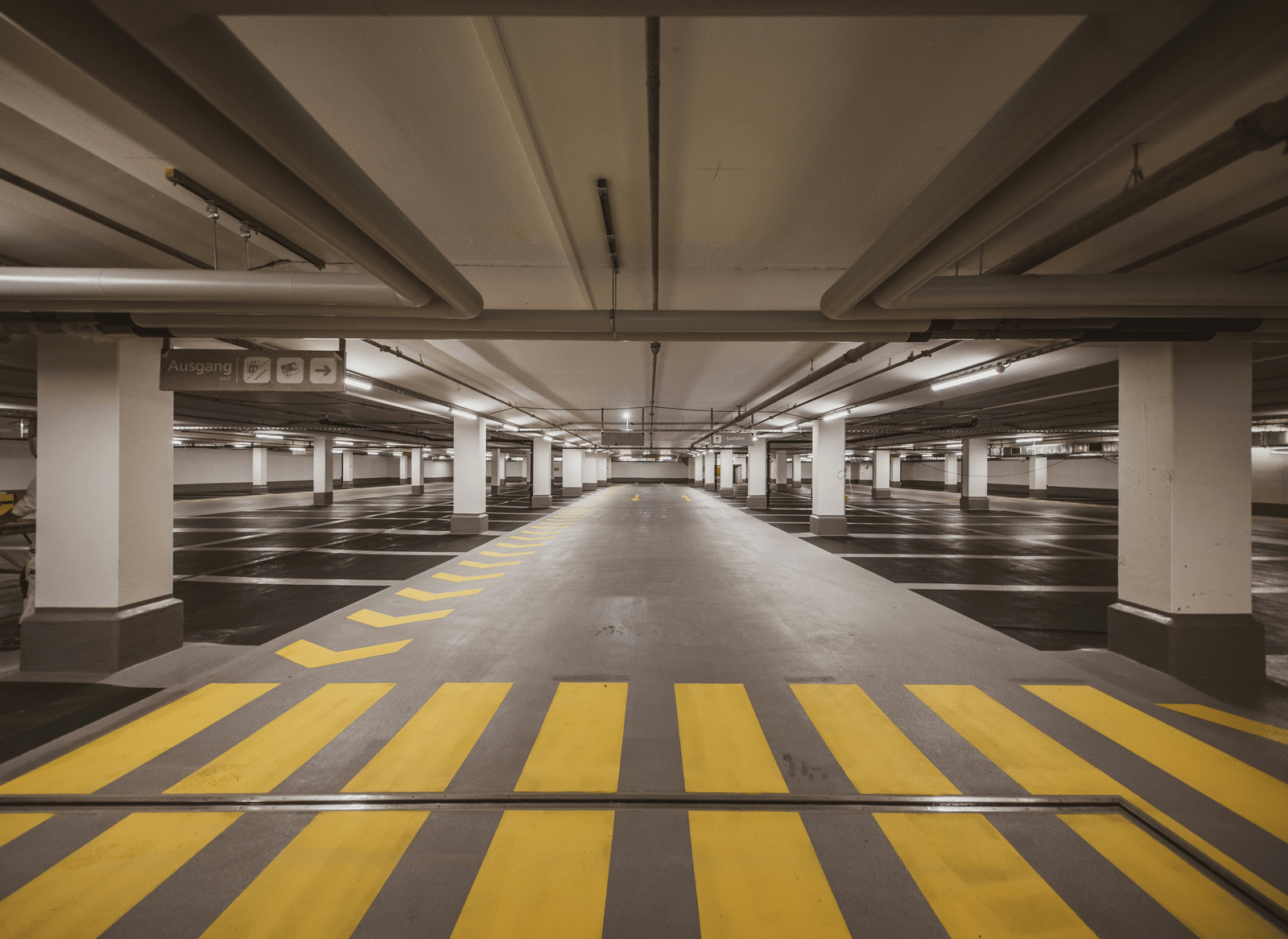 brightly lit, and empty parking lot with chevron arrows, and clear driving lane