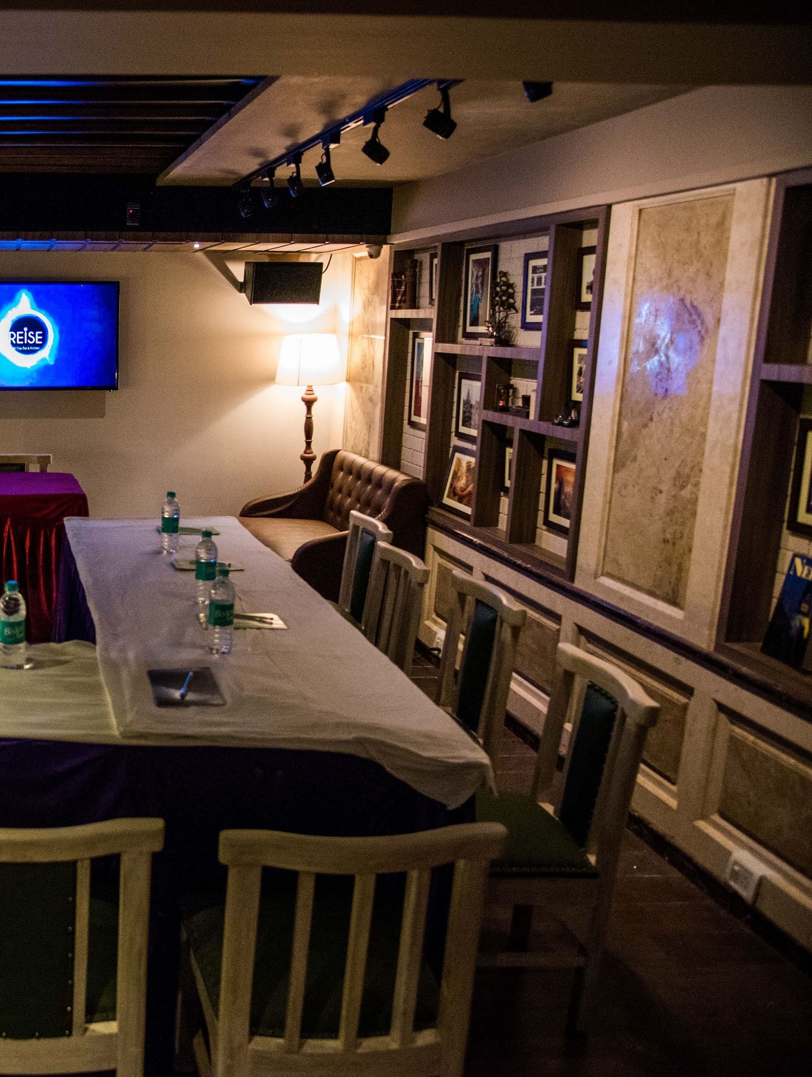 Cosy restaurant interior with a central table set for a meal under warm lighting at Oriental Aster, Mumbai.