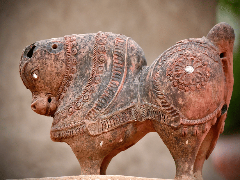 A close up shot of a small horse sculpture made of clay.