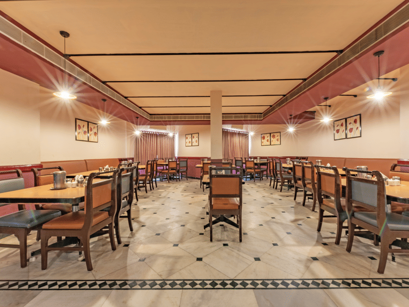Restaurant seating at Jayaram Hotel, Pondicherry designed for relaxed dining with spacious tables and comfortable chairs.