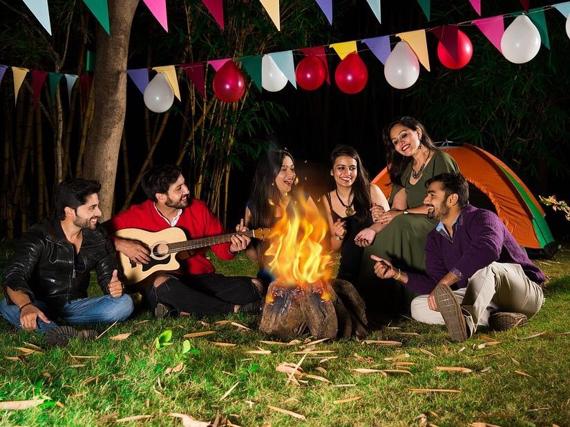 a group of people enjoying themselves at a bonfire