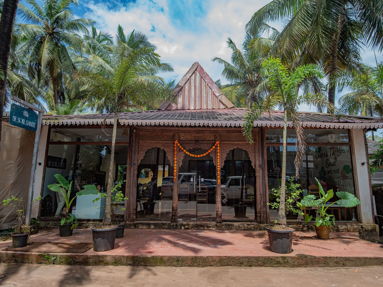 Main entrance with traditional Goan-style architecture surrounded by palm trees at De Soul Santé, Morjim