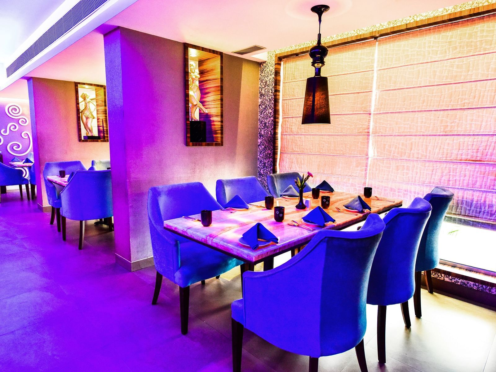 Image of Aqua Restaurant with seating area and dim lighting at Swosti Grand, Bhubaneswar