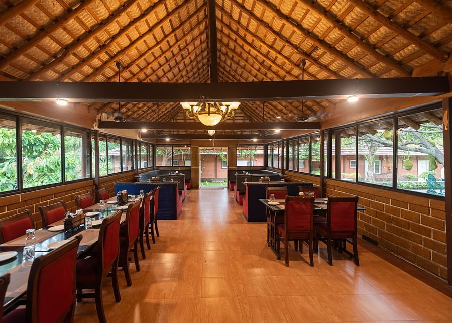 chairs and tables inside Aqua Restaurant at Ibex River Resort, Pollachi