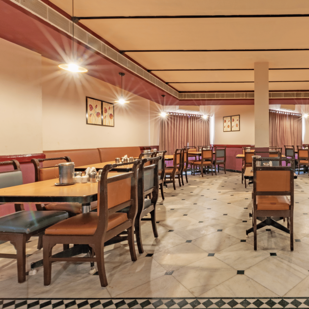 Restaurant seating at Jayaram Hotel, Pondicherry designed for relaxed dining with spacious tables and comfortable chairs.