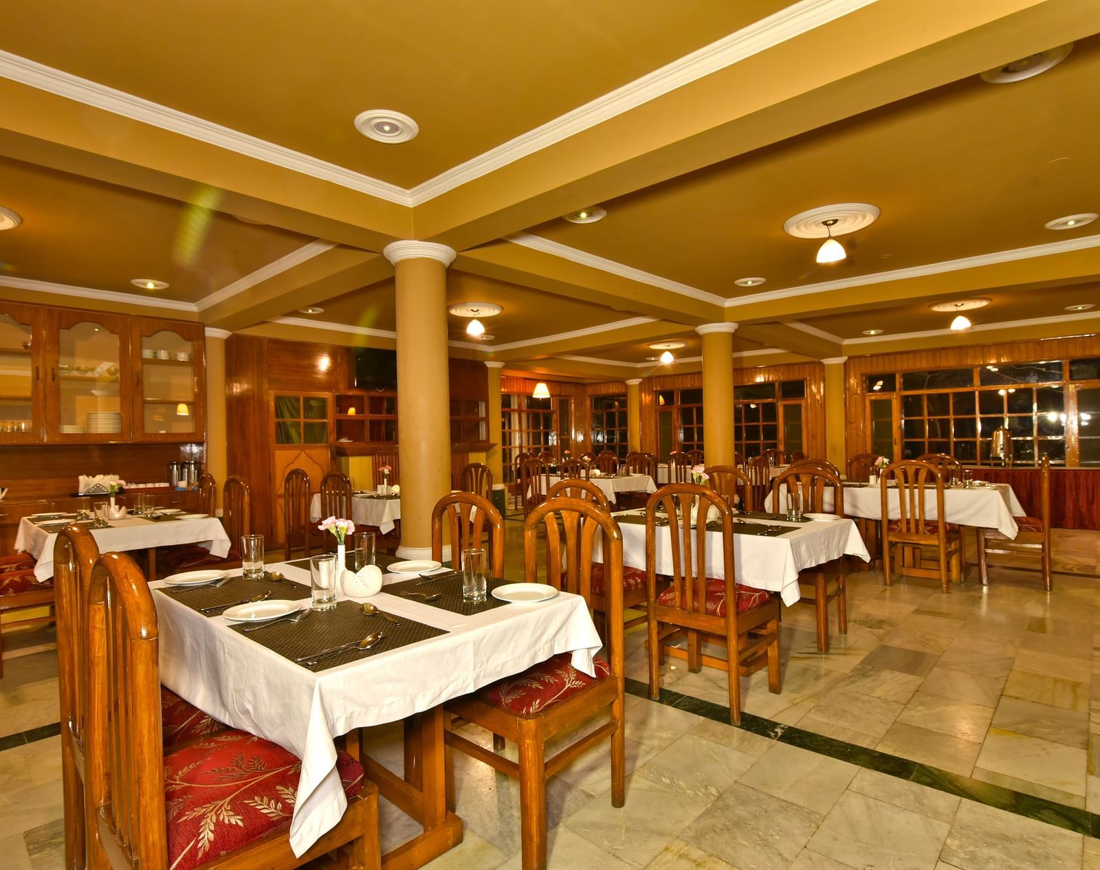 A cosy dining space with tables and chairs at DLS Hillcrest Resort, Shimla.