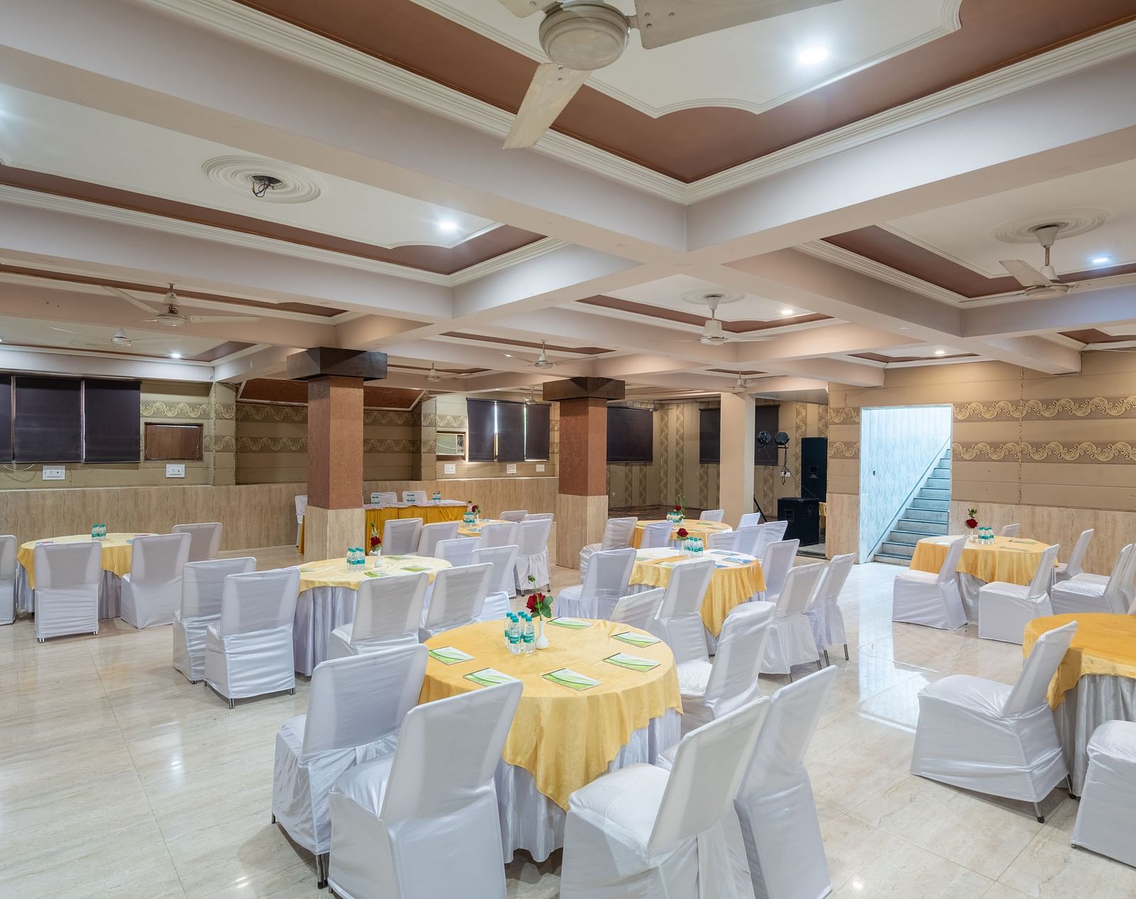 A banquet hall with decorated tables and chairs at DLS Park Grace, Haridwar.
