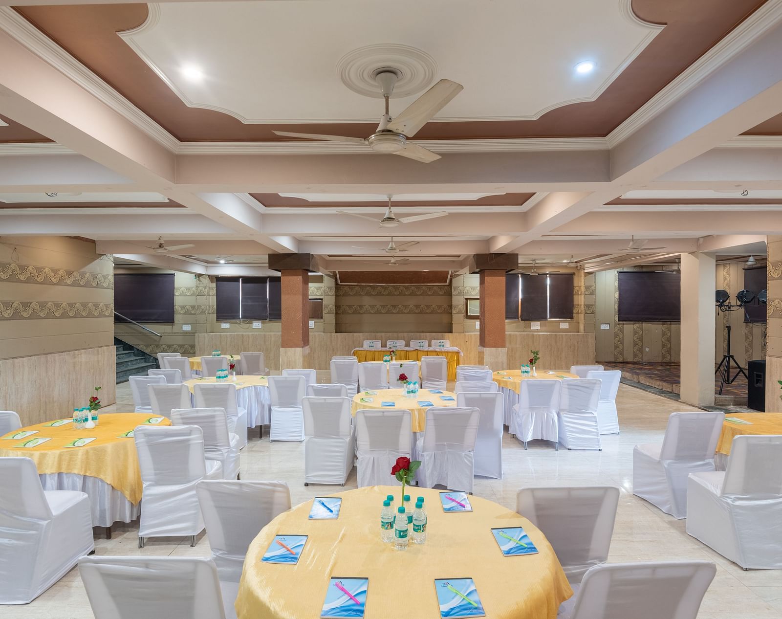Banquet hall with round tables and chairs at DLS Park Grace, Haridwar.