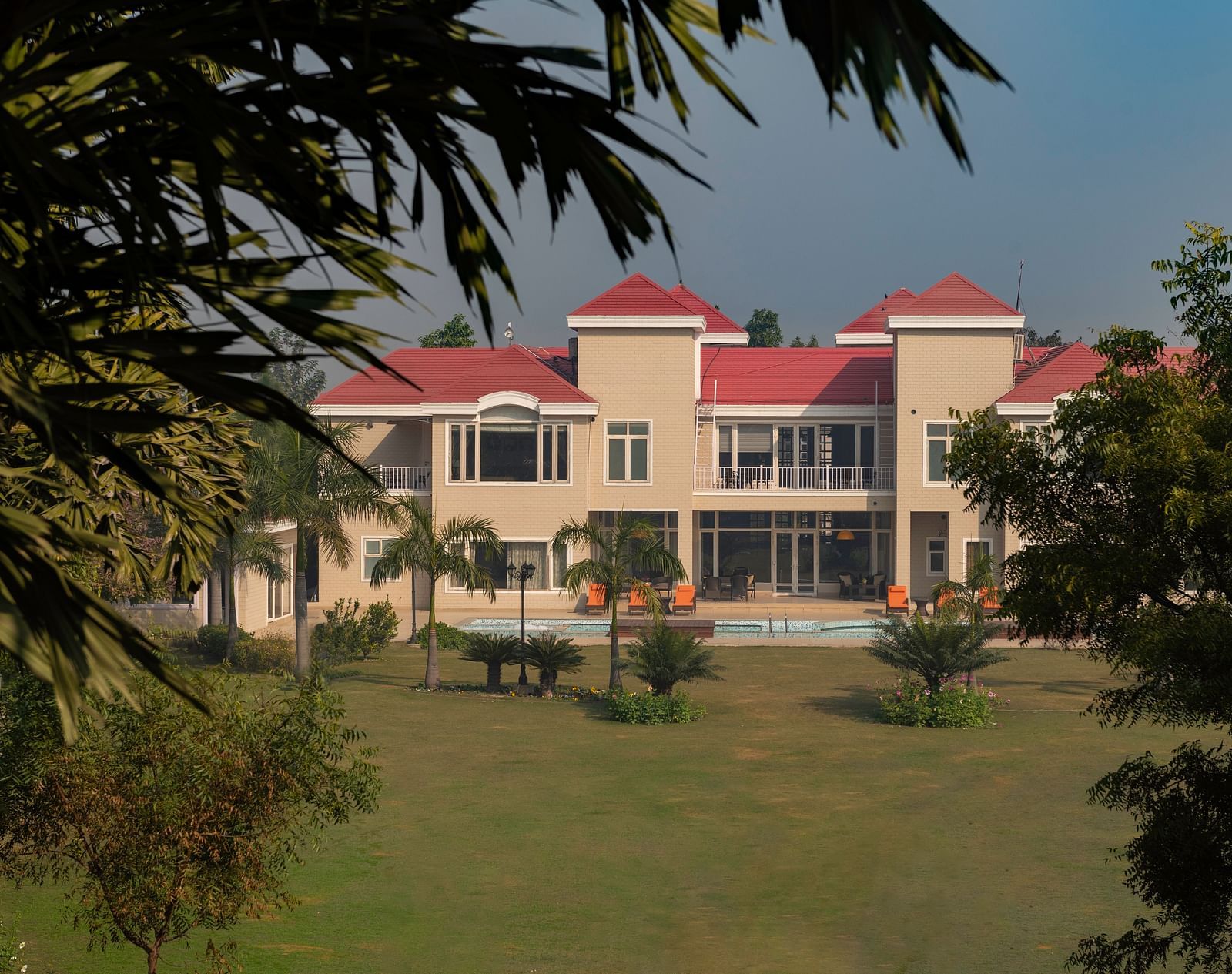 Facade view of BluSalzz Resort with garden and trees in the front.