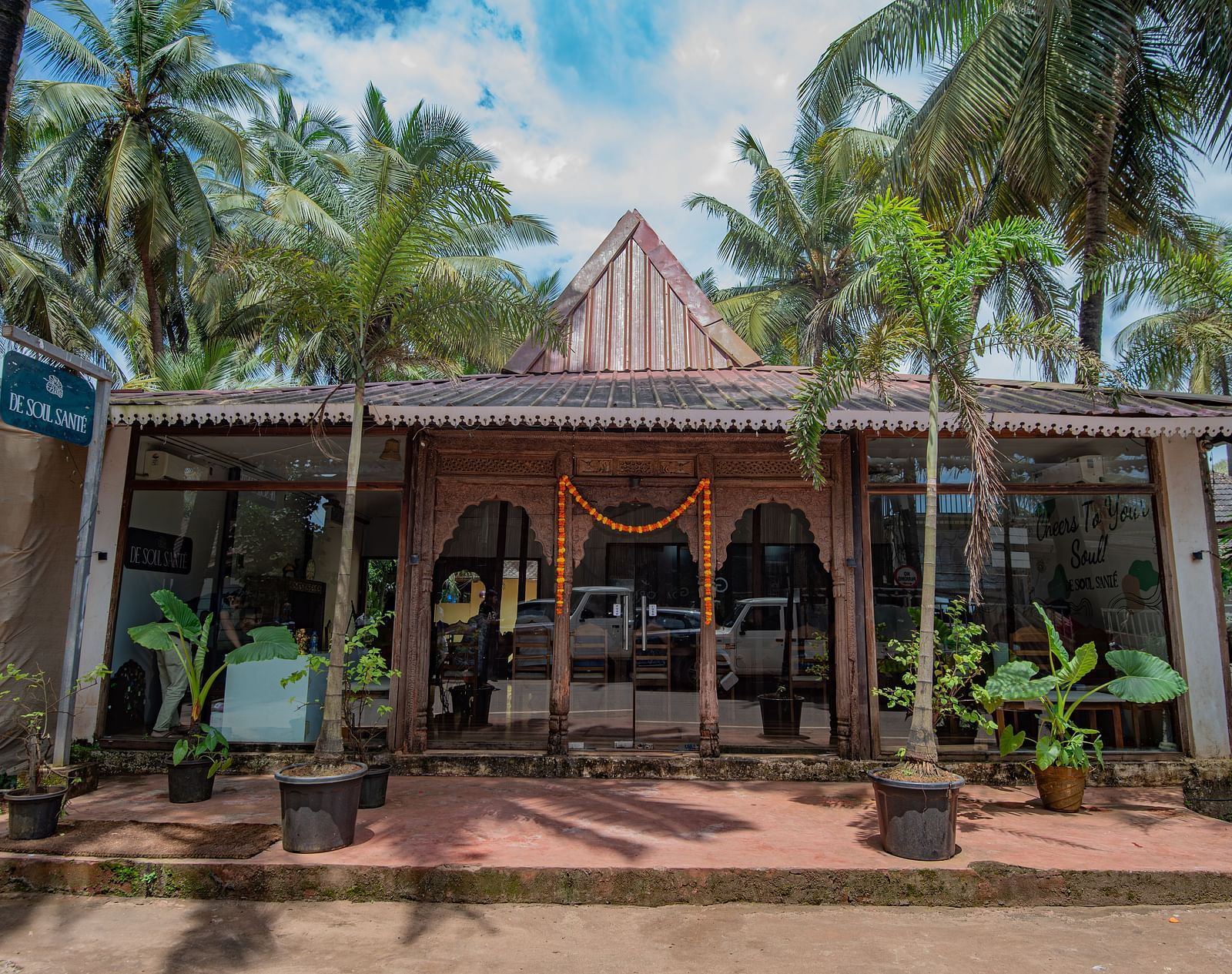 Main entrance with traditional Goan-style architecture surrounded by palm trees at De Soul Santé, Morjim