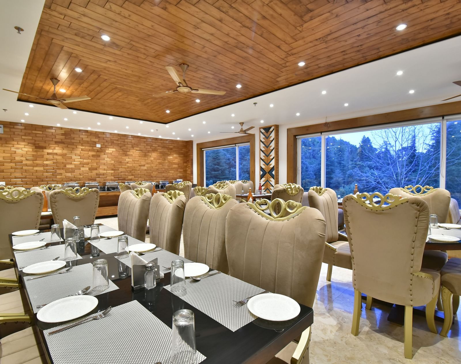 Dining area with comfortable chairs around tables at Rainbow Restaurant at DLS Ark Holiday Inn, Banikhet.