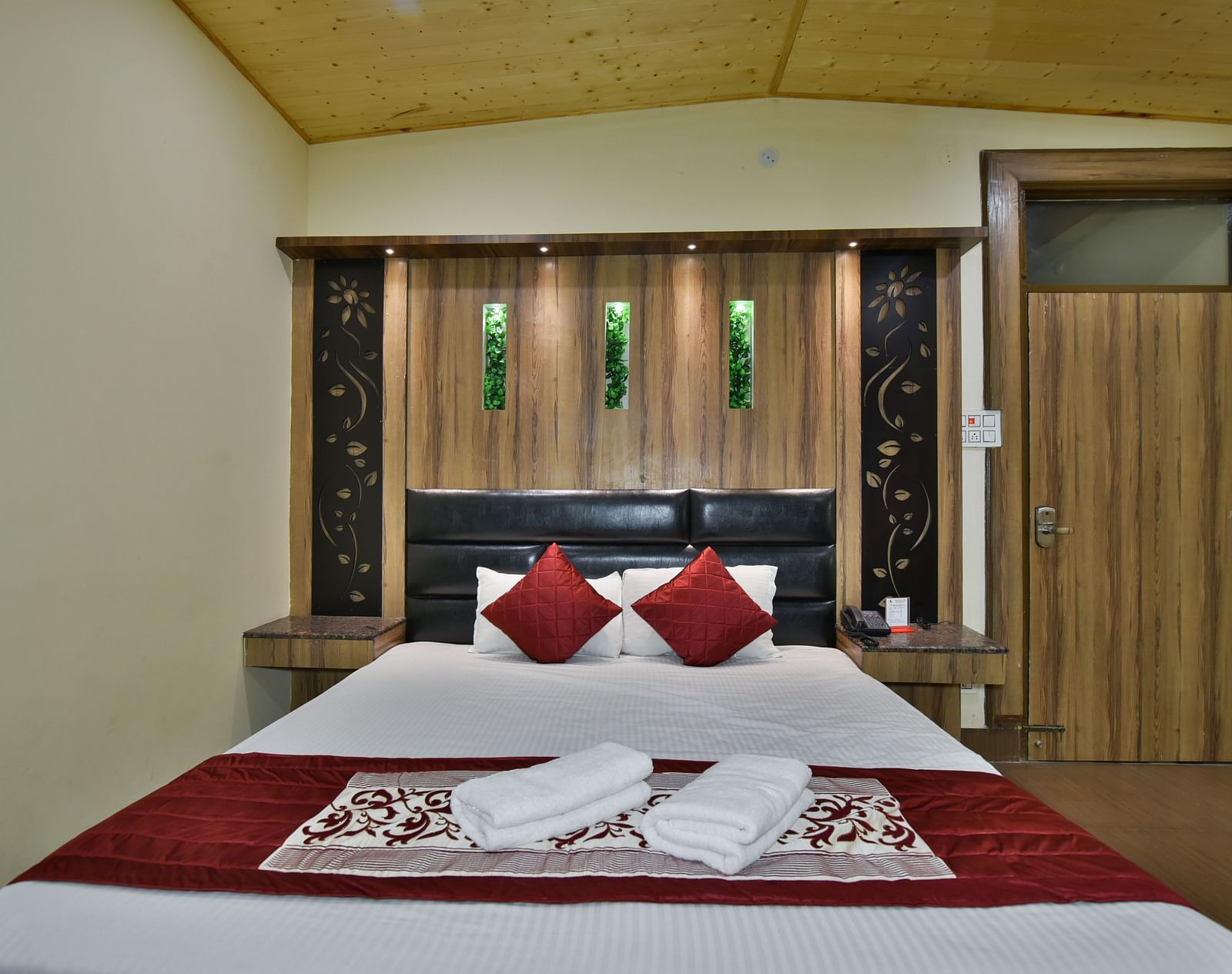 Family Suite at DLS Dalhousie Valley Resort with a king size bed and towels kept on bed.