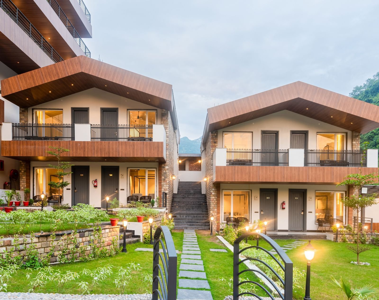 Facade of DLS Divine River Resort and Spa surrounded by lush green gardens and lamp posts.