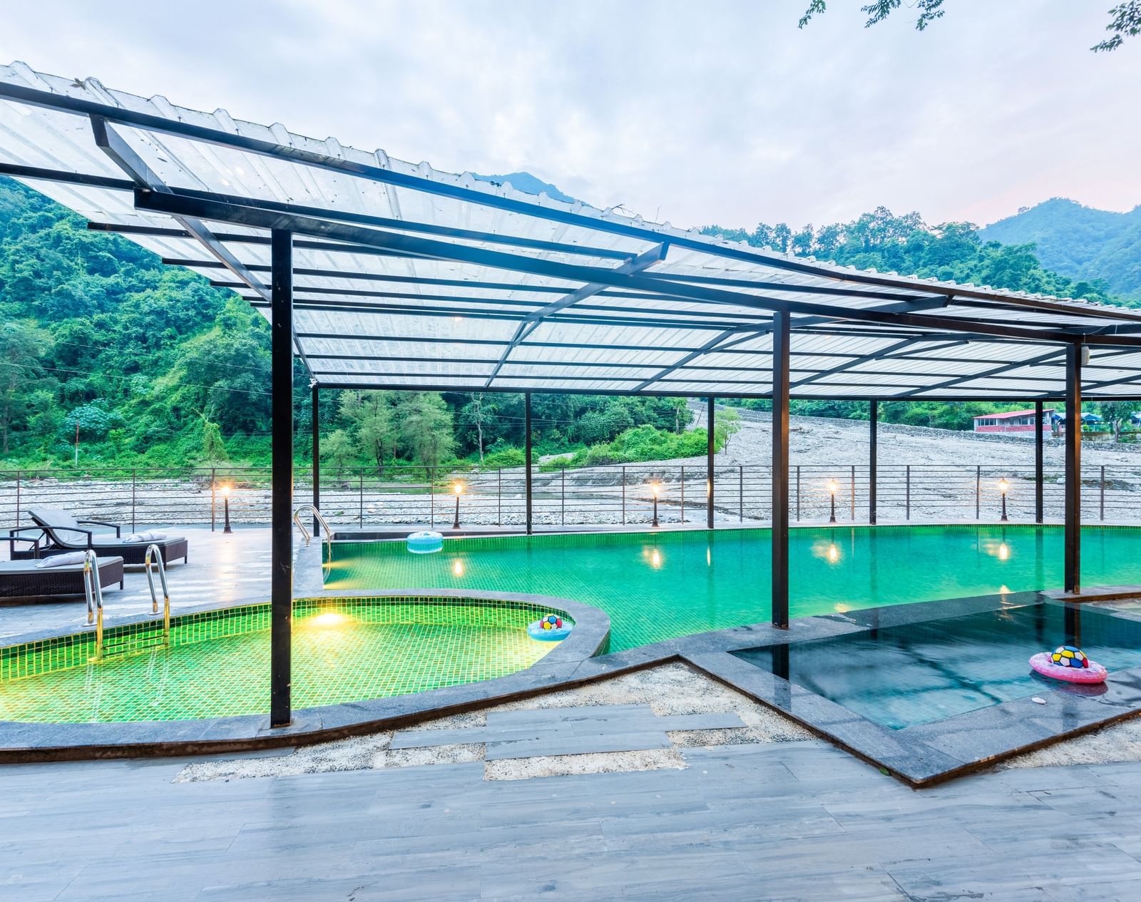 A swimming pool at DLS Divine Resort and Spa with serene views and kids pool area.