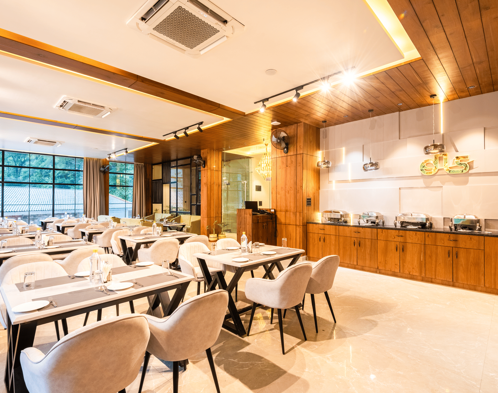 Restaurant at DLS Divine River Resort and Spa  with seating arrangement, large window and ambient lighting. 
