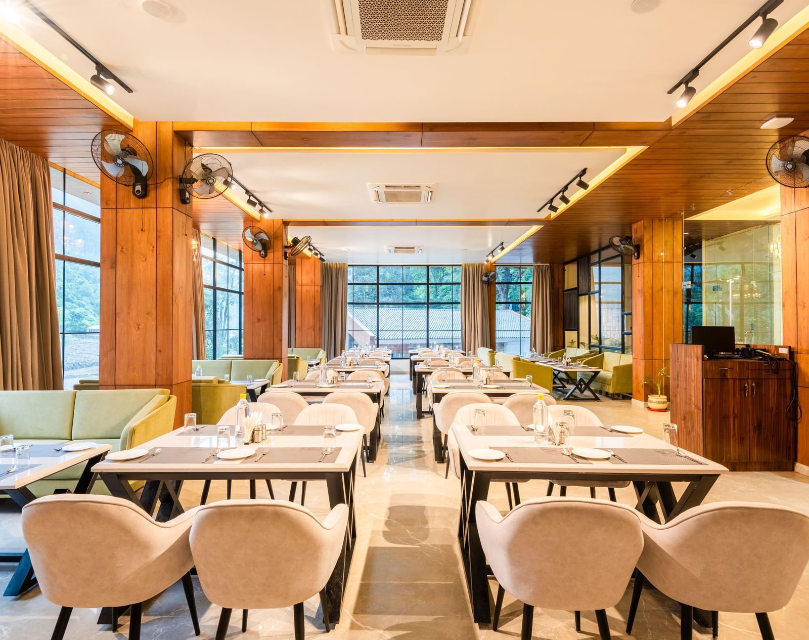 Restaurant at DLS Divine River Resort and Spa  with seating arrangement, large window and ambient lighting. 