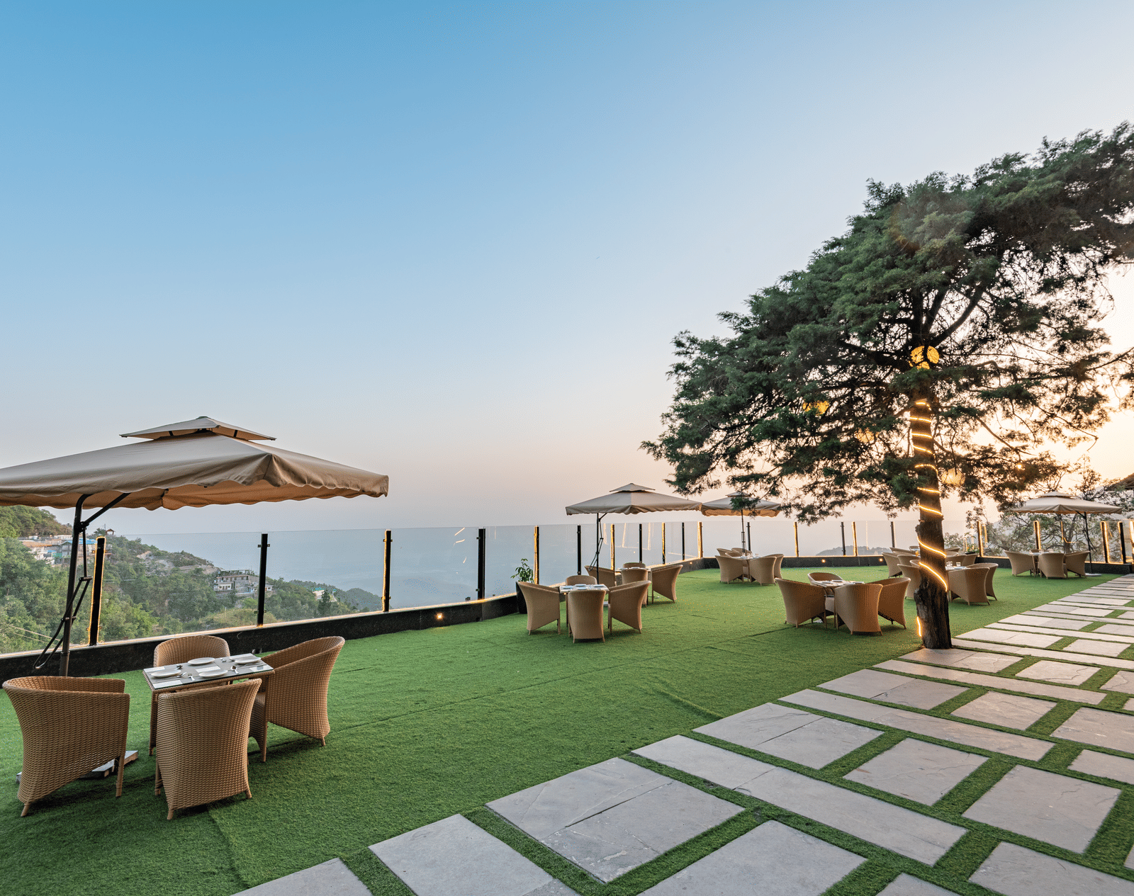 Comfortable seating in the lawn surrounded by hills at dusk at DLS Highland Resort and Spa, Mussoorie.