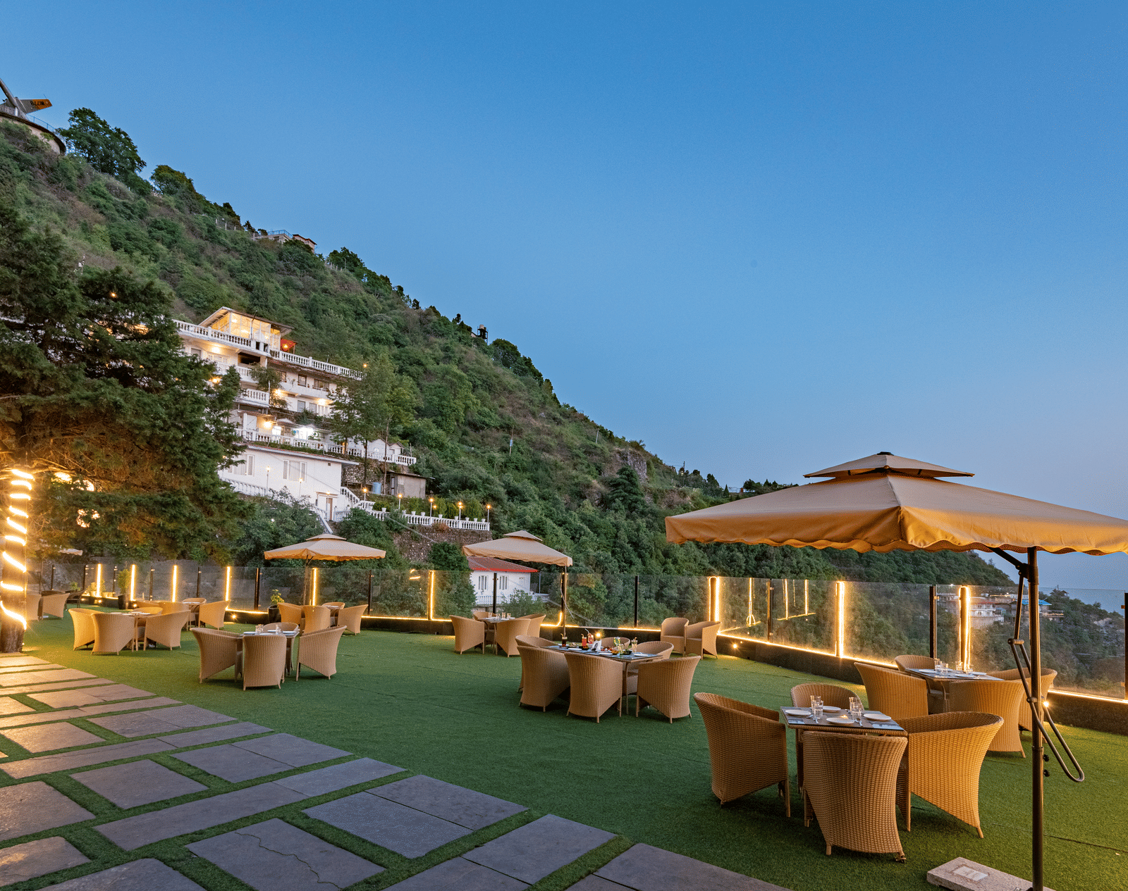 Comfortable seating in the lawn surrounded by hills at dusk at DLS Highland Resort and Spa, Mussoorie.