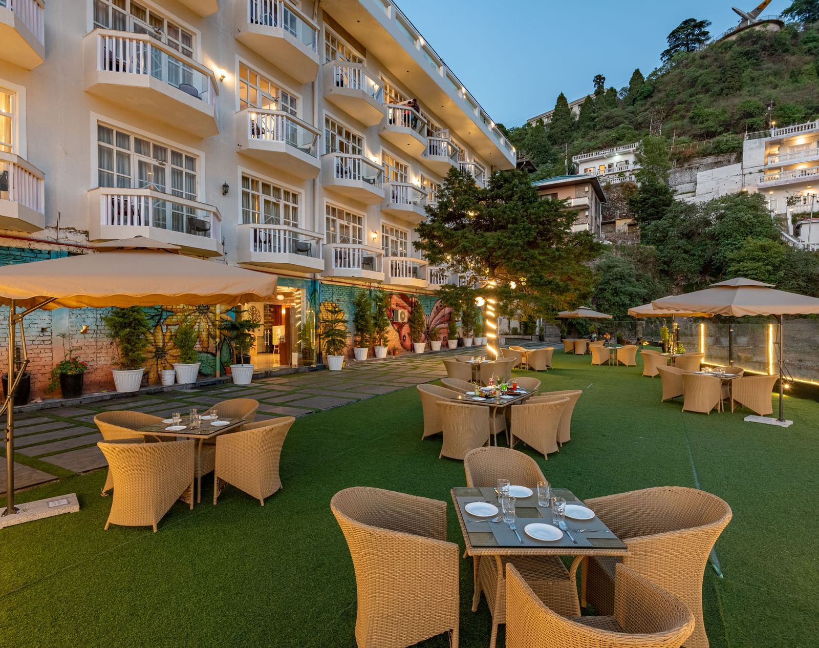 Comfortable seating in the lawn surrounded by hills at dusk at DLS Highland Resort and Spa, Mussoorie.