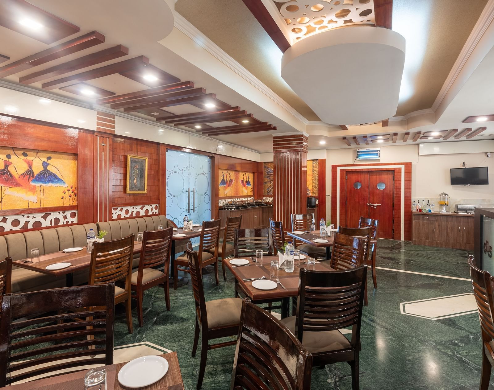 Dining area with wooden tables and chairs, featuring painted side walls at DLS Park Grace, Haridwar.