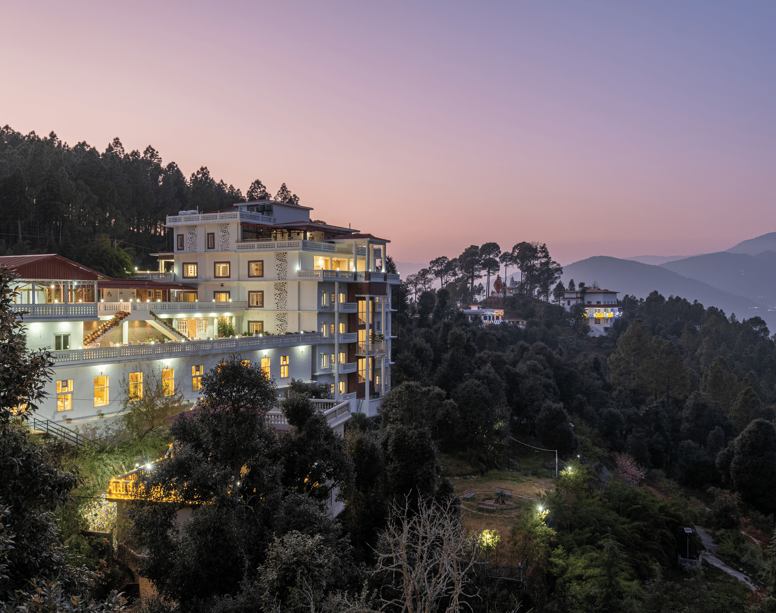 A panoramic view of the DLS Tehri Club Resort at sunset, nestled amidst the scenic hills.