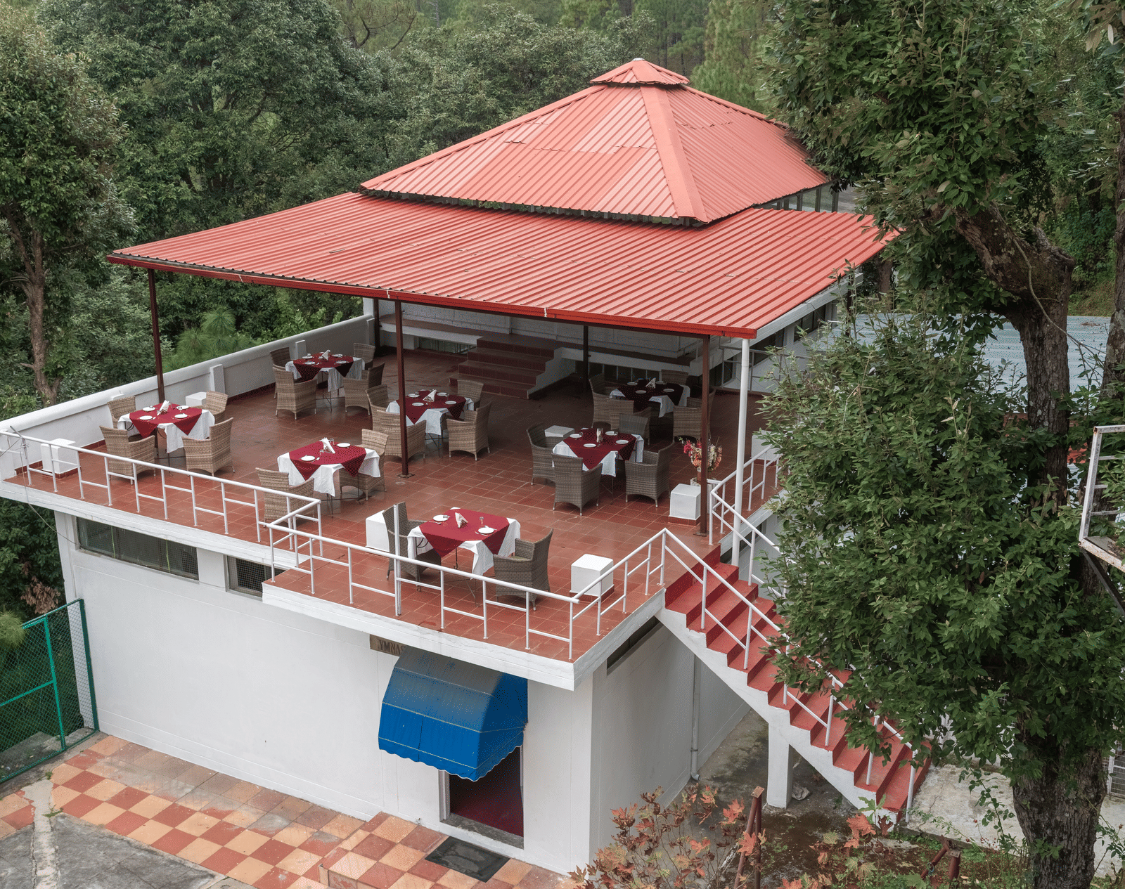 A charming outdoor restaurant at DLS Tehri Club Resort with a scenic view of the surrounding hills.