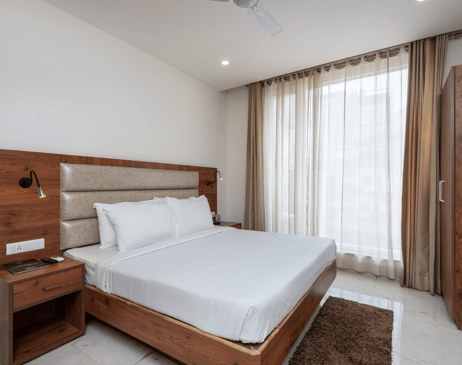 A Deluxe Room featuring a king size bed and a stylish patterned headboard at DLS The Classio