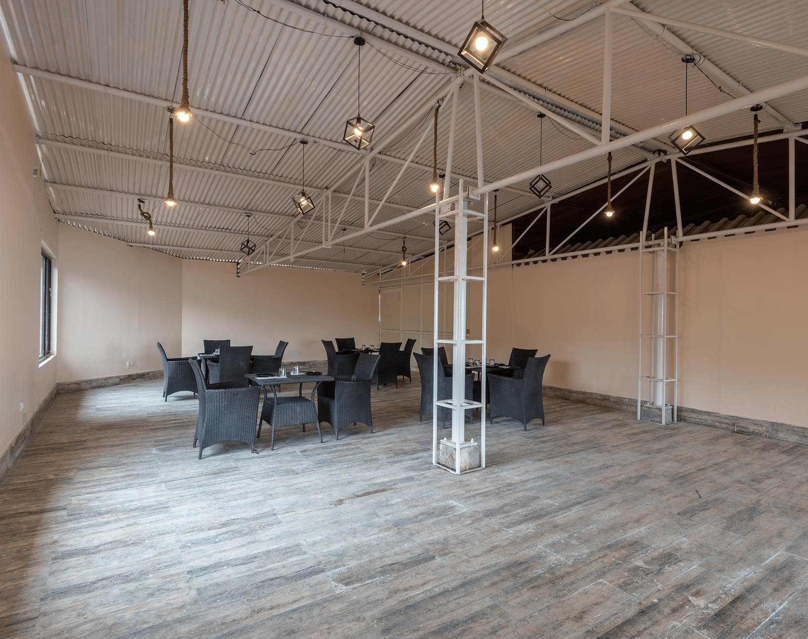 Shot of an empty conference hall with few chairs and tables kept around  | DLS The Pearl