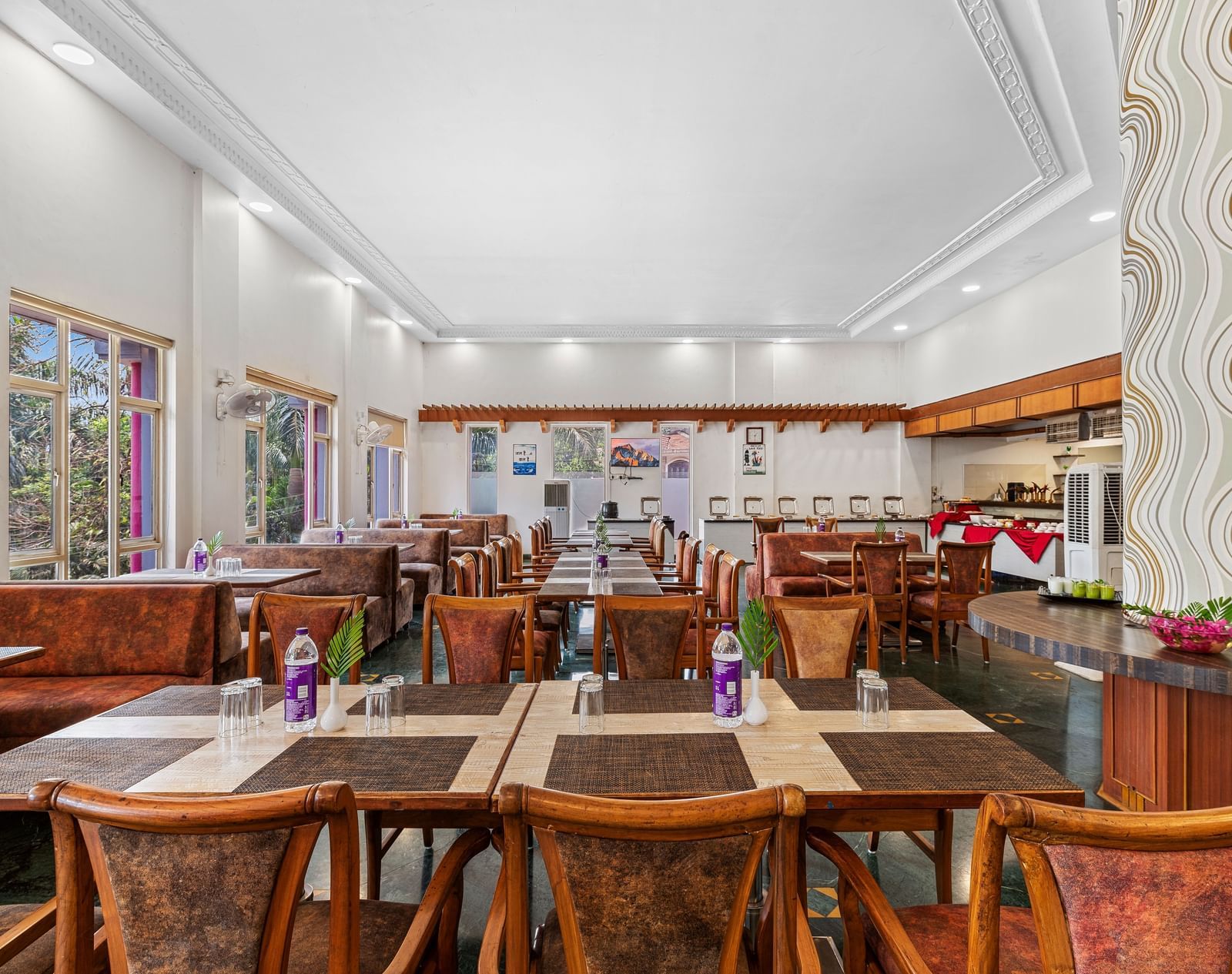 Indoor dining area with wooden furniture and colourful decor, part of The Darbar Restaurant at Mayur Retreat.