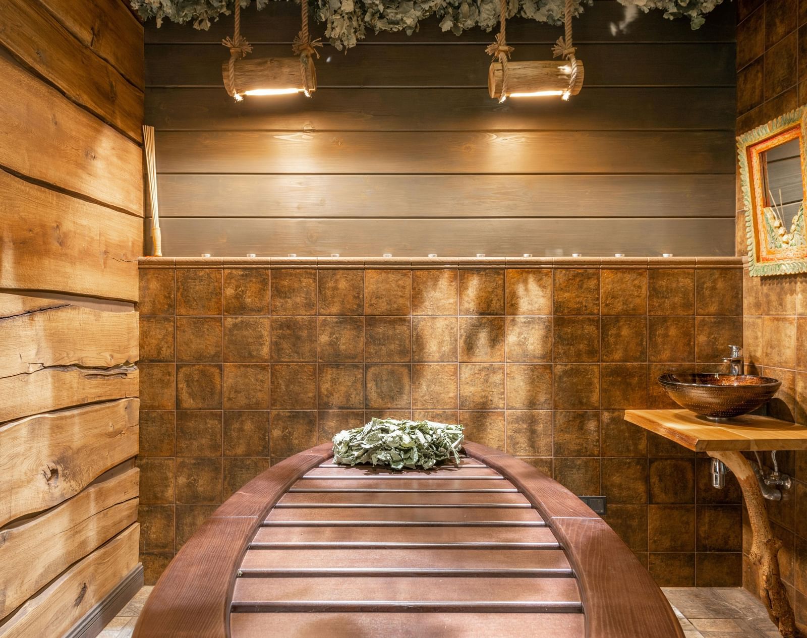 A spa room with wooden interiors showcasing a spa table, side table, and a photo frame.