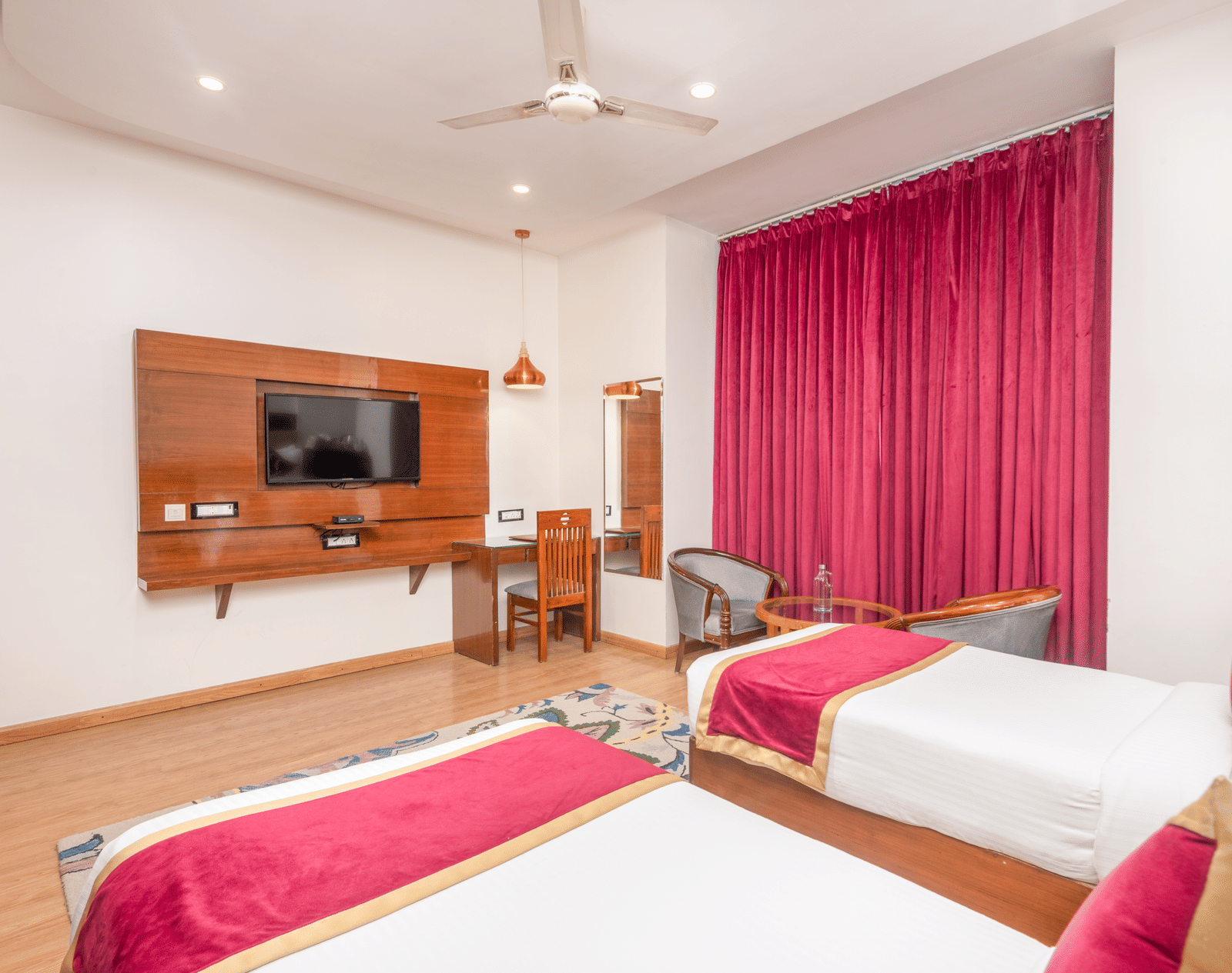 Twin bed room with TV and seating at DLS Hotels On The Ganges.