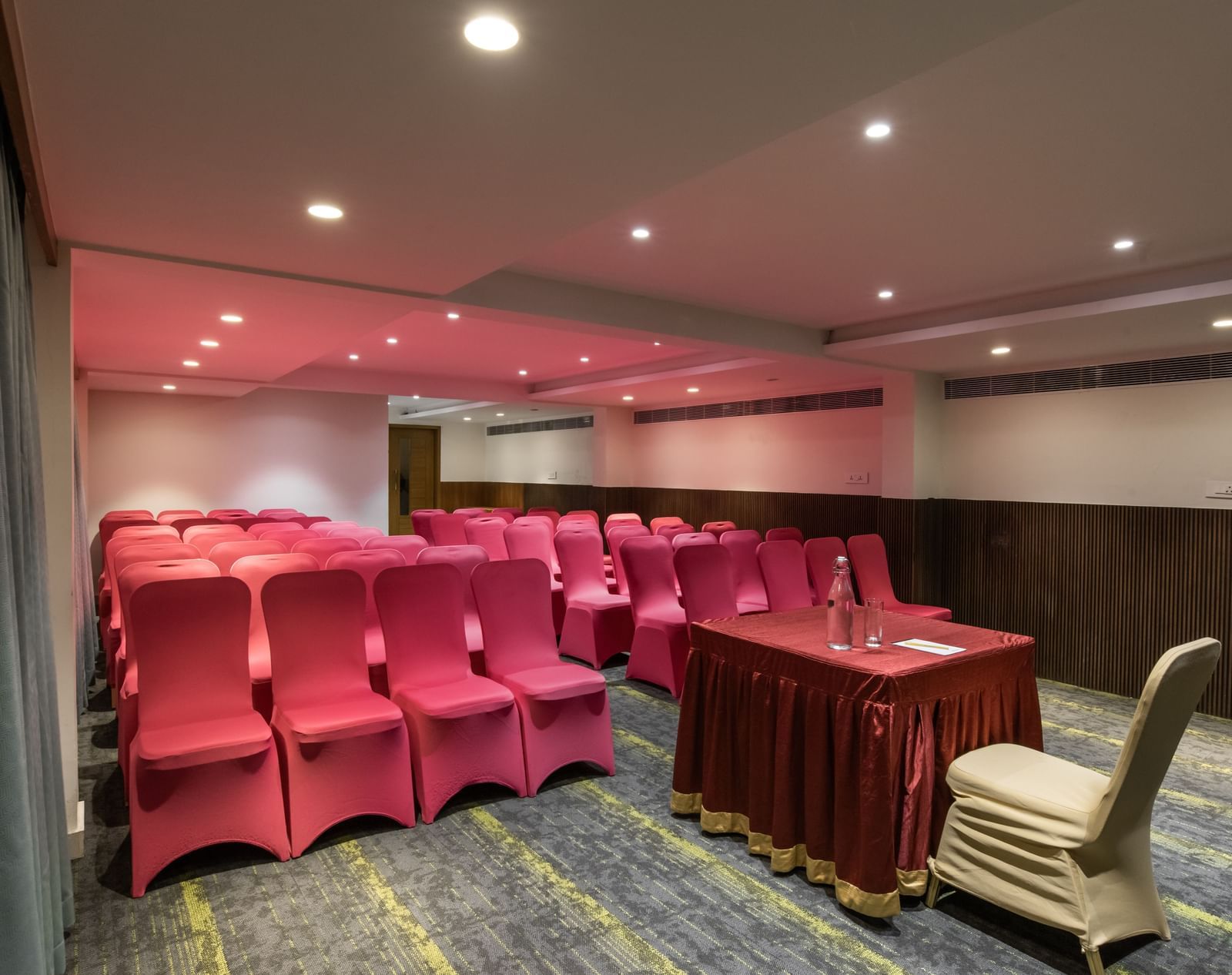 Event space with boardroom-style setup and red chairs at Hotel Royal Regency Chennai